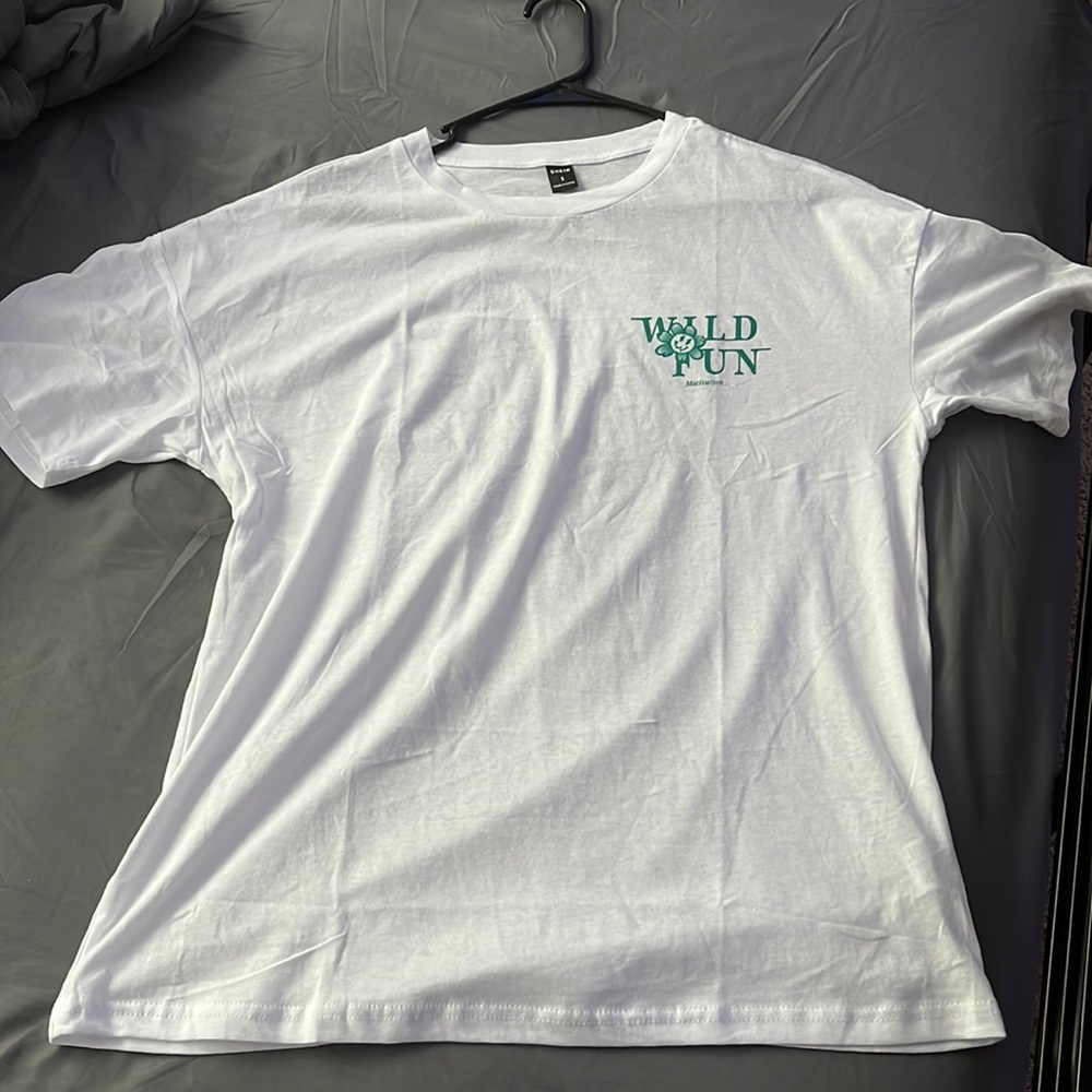 Never worn, white tee with green letters that say “Wild Fun”